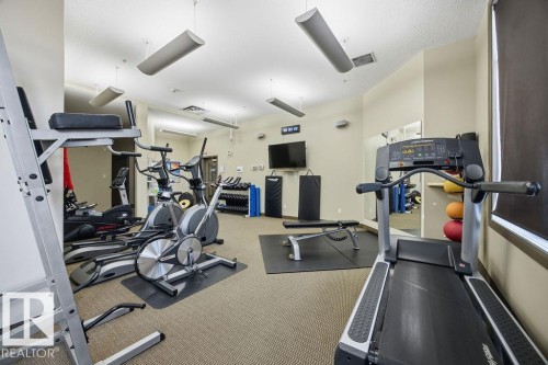 Fitness area with various exercise equipment, including treadmills, elliptical machines, and weights - 217 160 Magrath Road, Edmonton, AB - Indoor Photo Showing Gym Room