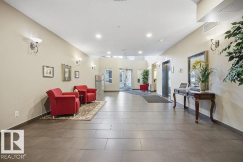 The property features a spacious lobby with tiled flooring and recessed lighting - 217 160 Magrath Road, Edmonton, AB - Indoor