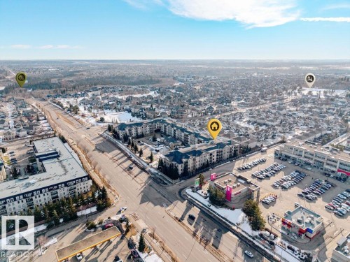 Aerial view of the property and its surrounding neighbourhood, featuring a mix of residential buildings and commercial establishments - 217 160 Magrath Road, Edmonton, AB -  With View
