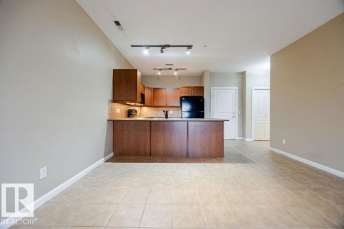 This photo shows the dining room is open to the kitchen and features ceramic tile flooring. - 217 160 Magrath Road, Edmonton, AB - Indoor Photo Showing Kitchen
