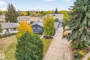 This property features a blue exterior, a grey roof, and a paved driveway leading to an attached garage - 15701 92A Avenue, Edmonton, AB  - Outdoor 