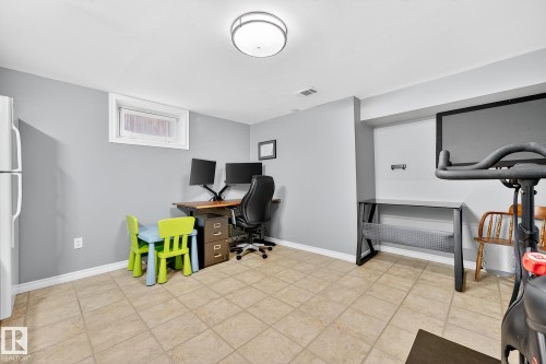 This versatile space features tiled flooring, a window, and a ceiling light fixture - 15701 92A Avenue, Edmonton, AB - Indoor