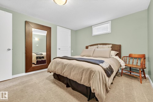 This room features light green walls, a neutral carpet, and a window with white blinds - 15701 92A Avenue, Edmonton, AB - Indoor Photo Showing Bedroom