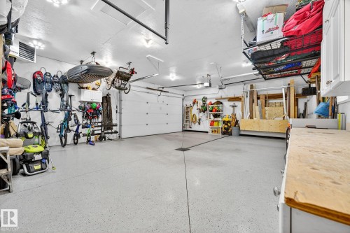 The garage features a light-colored floor, overhead lighting, and white garage doors - 15701 92A Avenue, Edmonton, AB - Indoor Photo Showing Garage