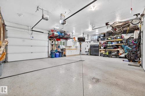 The property features an attached garage with a light-colored, speckled floor and two white garage doors - 15701 92A Avenue, Edmonton, AB - Indoor Photo Showing Garage