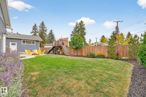 The property features a spacious backyard with a well-maintained lawn and a wooden fence - 15701 92A Avenue, Edmonton, AB - Outdoor