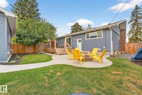 The property features a spacious backyard with a lawn, a concrete patio area, and a wooden deck - 15701 92A Avenue, Edmonton, AB - Outdoor