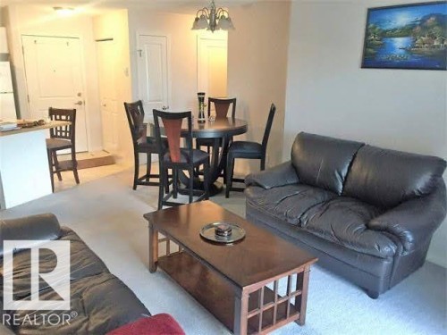 This inviting living space features carpeting, a ceiling light fixture, and a white entrance door - 136 16221 95 Street, Edmonton, AB - Indoor Photo Showing Living Room
