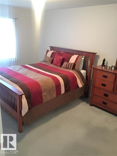 This room features light-colored walls, a window providing natural light, and a light-colored carpet - 136 16221 95 Street, Edmonton, AB - Indoor Photo Showing Bedroom