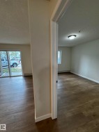Expansive interior space featuring wood-finish flooring, neutral wall tones, and white trim - 