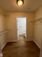 Walk-in closet featuring wood-finish flooring, wire shelving, and a flush mount ceiling light - 
