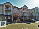 The property features a multi-story building with a stucco exterior and pitched roofs - 136 16221 95 Street, Edmonton, AB  - Outdoor With Balcony With Facade 
