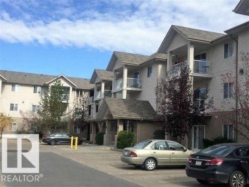 The property features multiple levels with balconies and covered entrances, set within a paved parking area - 136 16221 95 Street, Edmonton, AB - Outdoor With Balcony With Facade