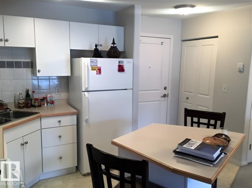 Kitchen area featuring white cabinetry, a white refrigerator, and a light-colored countertop - 136 16221 95 Street, Edmonton, AB - Indoor Photo Showing Kitchen