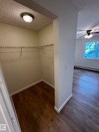 Storage closet featuring wood-finish flooring, wire shelving, and overhead lighting - 