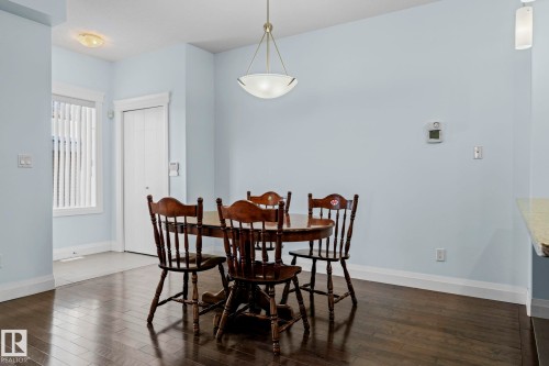 Dining area featuring hardwood floors, light blue walls, and a pendant light fixture - 12913 124 Street, Edmonton, AB - Indoor Photo Showing Dining Room