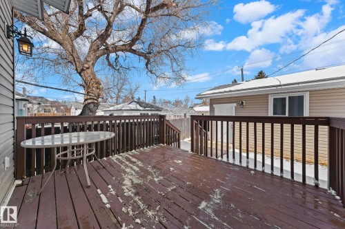 The property features a spacious outdoor deck with dark wood railing and deck boards, offering an inviting space for enjoyment - 12913 124 Street, Edmonton, AB - Outdoor With Deck Patio Veranda