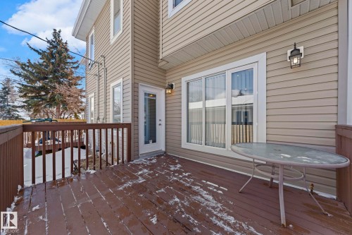 This property features a wooden deck with a protective railing and direct access to the interior via a glass-paneled door - 12913 124 Street, Edmonton, AB - Outdoor With Exterior