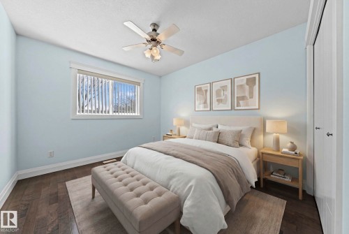 This room features dark wood flooring, light blue walls, and a ceiling fan - 12913 124 Street, Edmonton, AB - Indoor Photo Showing Bedroom