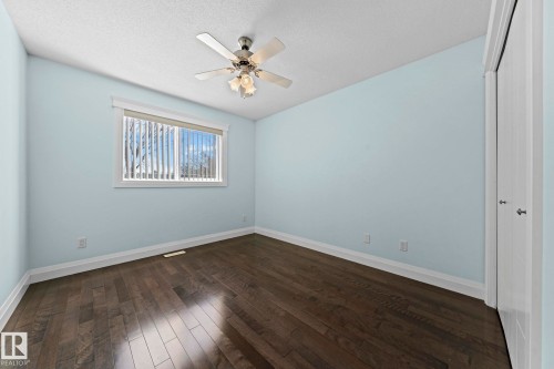 The room features dark hardwood flooring and a window with blinds - 12913 124 Street, Edmonton, AB - Indoor Photo Showing Other Room