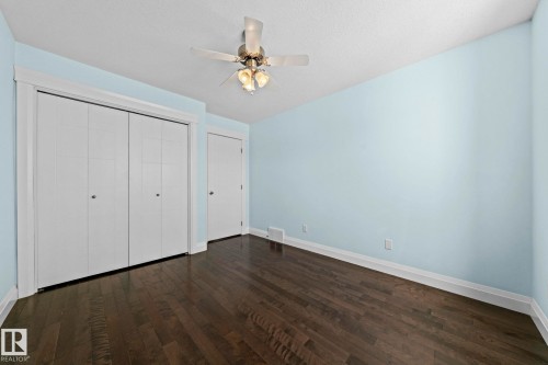 This room features dark hardwood flooring, light blue walls, and white trim - 12913 124 Street, Edmonton, AB - Indoor Photo Showing Other Room