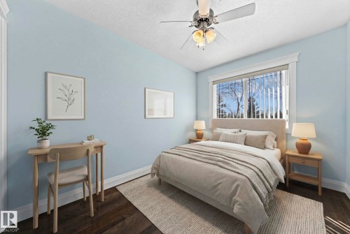 The property features a room with dark wood flooring, light blue walls, and a window with vertical blinds - 12913 124 Street, Edmonton, AB - Indoor Photo Showing Bedroom