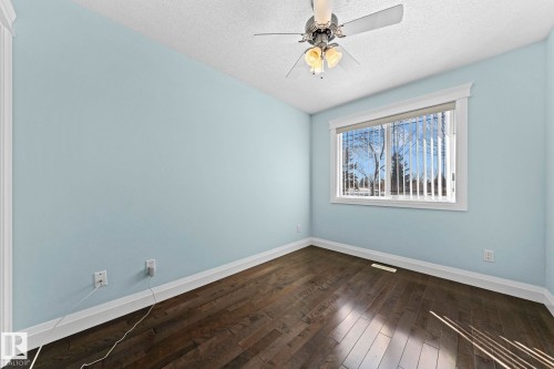 The room features hardwood floors, light blue walls, and a window with vertical blinds - 12913 124 Street, Edmonton, AB - Indoor Photo Showing Other Room