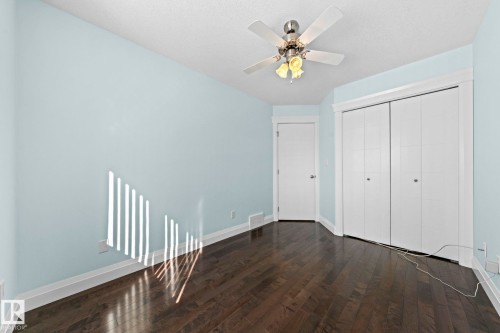This room features dark wood flooring, light blue walls, and white trim - 12913 124 Street, Edmonton, AB - Indoor Photo Showing Other Room