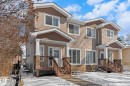 The property features light-colored siding, a stone facade, and a covered porch with wooden railings - 12913 124 Street, Edmonton, AB  - Outdoor With Facade 