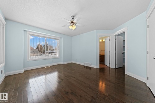 The room features hardwood floors, a large window providing natural light, and a ceiling fan - 12913 124 Street, Edmonton, AB - Indoor Photo Showing Other Room
