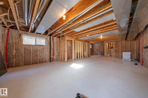 The property features an unfinished basement with exposed wooden beams, ductwork, and framing, offering a versatile space for future development - 12913 124 Street, Edmonton, AB - Indoor Photo Showing Basement