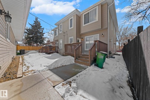 The property features a private outdoor area with wooden decks and fencing, offering outdoor access from the rear of the building - 12913 124 Street, Edmonton, AB - Outdoor
