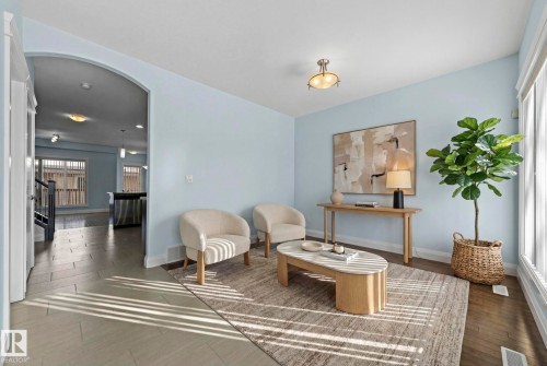 Living area featuring light blue walls, hardwood flooring, and an arched entryway - 12913 124 Street, Edmonton, AB - Indoor