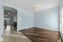 This inviting room features hardwood flooring, light blue walls, and a contemporary ceiling light fixture - 12913 124 Street, Edmonton, AB  - Indoor Photo Showing Other Room 