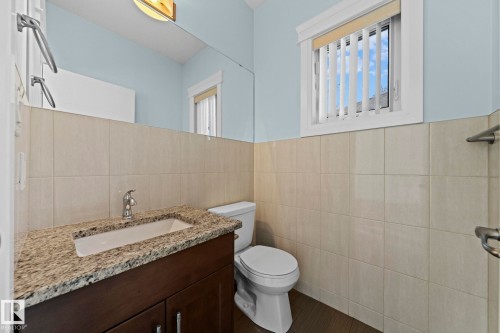 The bathroom features a vanity with a granite countertop, a rectangular sink, and a modern faucet - 12913 124 Street, Edmonton, AB - Indoor Photo Showing Bathroom