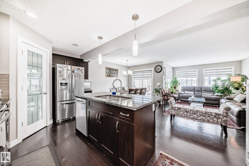 Frosted glass pantry door, view to the dining area, living room and exit to the deck. - 1723 Hammond Crescent Nw, Edmonton, AB - Indoor Photo Showing Kitchen With Double Sink With Upgraded Kitchen