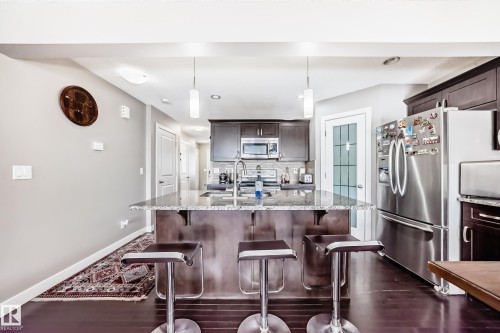 Drop down counter for family to oversee the chef. Stools add to the area for conversations. - 1723 Hammond Crescent Nw, Edmonton, AB - Indoor Photo Showing Kitchen With Upgraded Kitchen