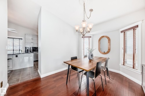 Dining area featuring hardwood floors and a chandelier, with a view into the kitchen - 3107 43 Avenue, Edmonton, AB - Indoor Photo Showing Dining Room