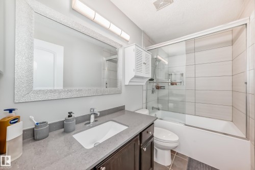 Bathroom featuring a vanity with a rectangular sink, a gray countertop, and a large framed mirror - 3107 43 Avenue, Edmonton, AB - Indoor Photo Showing Bathroom