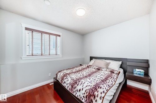 The room features rich hardwood flooring, a window with horizontal blinds, and a built-in floating nightstand - 3107 43 Avenue, Edmonton, AB - Indoor Photo Showing Bedroom