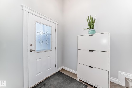 Entryway featuring a white door with decorative glass inserts, light grey walls, and a tiled floor - 3107 43 Avenue, Edmonton, AB - Indoor Photo Showing Other Room