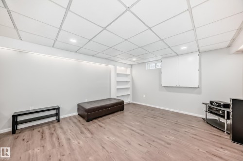 This versatile room features light wood-look flooring, built-in shelving, and recessed lighting - 3107 43 Avenue, Edmonton, AB - Indoor Photo Showing Other Room