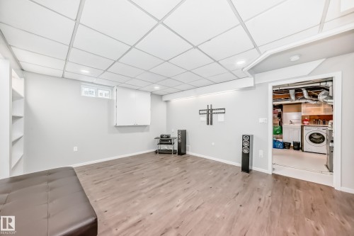 This versatile room features light wood-look flooring, recessed lighting, and built-in shelving - 3107 43 Avenue, Edmonton, AB - Indoor