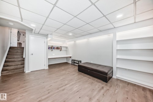 This room features wood-look flooring, built-in shelving, and recessed lighting - 3107 43 Avenue, Edmonton, AB - Indoor Photo Showing Other Room