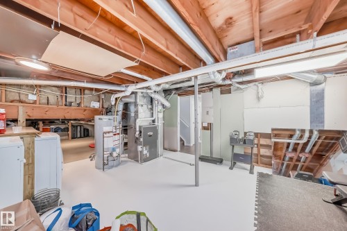 The property includes a utility area with exposed wooden ceiling beams and a painted floor - 3107 43 Avenue, Edmonton, AB - Indoor Photo Showing Basement