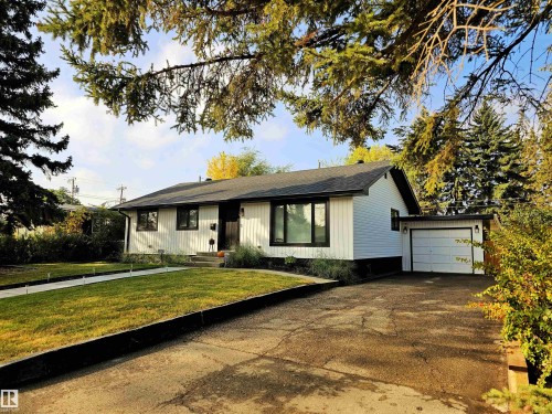 The property features a white exterior, a dark roof, and an attached garage with a white door - 8604 142 Street, Edmonton, AB - Outdoor