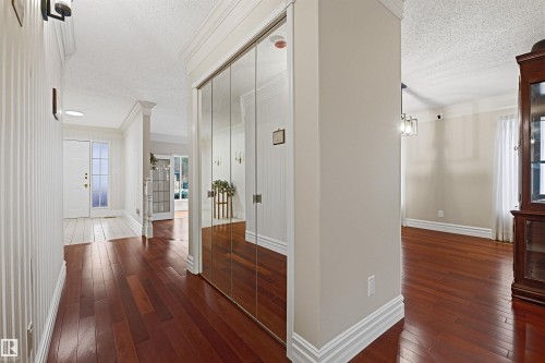 Entryway with hardwood floors, a white front door with frosted glass, and mirrored closet doors - 131 Walsh Crescent, Edmonton, AB - Indoor Photo Showing Other Room