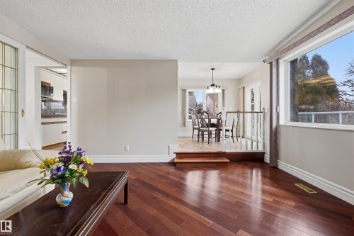 The interior of the property features rich hardwood flooring and large windows, providing views of the outdoors - 131 Walsh Crescent, Edmonton, AB - Indoor Photo Showing Other Room