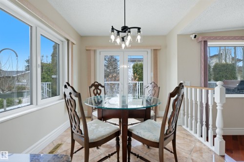 Dining area featuring tile flooring, a glass-top table, and a white balustrade - 131 Walsh Crescent, Edmonton, AB - Indoor Photo Showing Dining Room