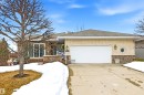 The property features a brick and stone exterior, a driveway, and an attached garage with a white door - 131 Walsh Crescent, Edmonton, AB  - Outdoor 